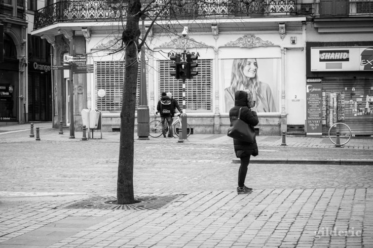 Liège en quarantaine (coronavirus) : une femme seule attend (photo en noir et blanc)